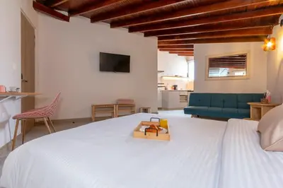 a bedroom with a white bed and a blue couch at Spacious Laureles Apt-SuperHost-AC-WIFI in Medellín