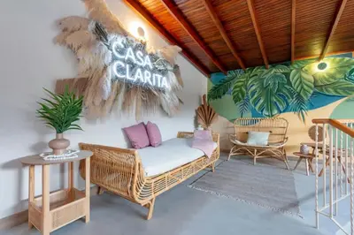 a room with a wicker chair and a sign on the wall at Modern Cozy Apt - Laureles -AC - Fast WiFi in Medellín