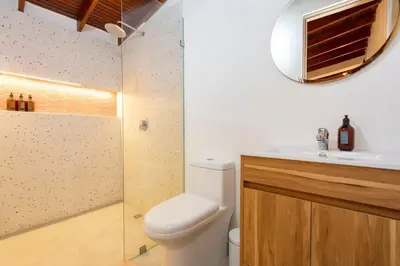a bathroom with a toilet and a sink and a mirror at Modern Cozy Apt - Laureles -AC - Fast WiFi in Medellín