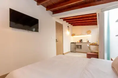 a bedroom with a bed and a television on a wall at Modern Cozy Apt - Laureles -AC - Fast WiFi in Medellín