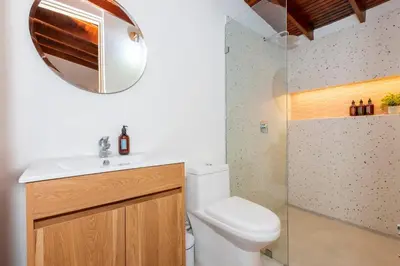 a bathroom with a toilet and a sink and a mirror at Laureles Apt-Eco-Smart Locks-AC-Super Location in Medellín