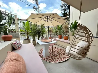 a patio with a chair and a table and an umbrella at Laureles Apt-Eco-Smart Locks-AC-Super Location in Medellín