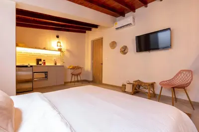 a bedroom with a white bed and a tv on the wall at Laureles Apt-Smart locks-Excellent Location-AC in Medellín