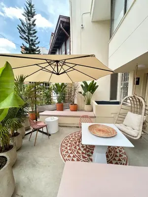 a patio with a table and an umbrella at Spacious Laureles Apt-Smart Lock-Queen Bed-AC in Medellín