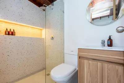 a bathroom with a toilet and a sink and a mirror at Spacious Laureles Apt-Smart Lock-Queen Bed-AC in Medellín