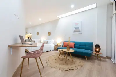 a living room with a blue couch and a bed at Large Apt-Laureles-Smart Lock-AC-Laundry Service in Medellín