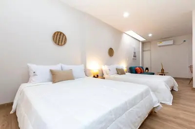 two beds in a room with white walls at Large Apt-Laureles-Smart Lock-AC-Laundry Service in Medellín