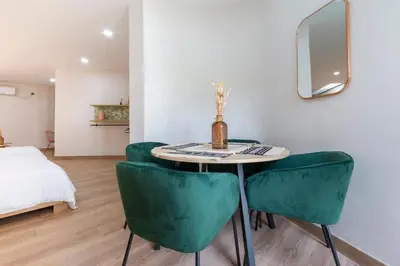 a room with a table and green chairs at Large Apt-Laureles-Smart Lock-AC-Laundry Service in Medellín