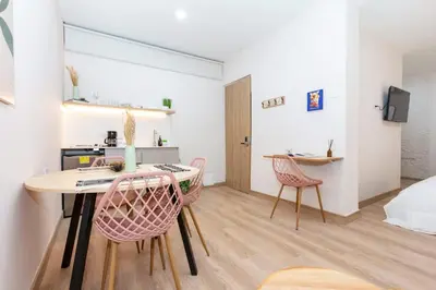 a room with a table and chairs and a bedroom at Spacious Apt -Laureles -AC -Smart Lock- WiFi in Medellín