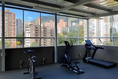 a gym with two exercise bikes in a room with windows at Provenza Life 603 - Chic Urban Retreat in El Poblado