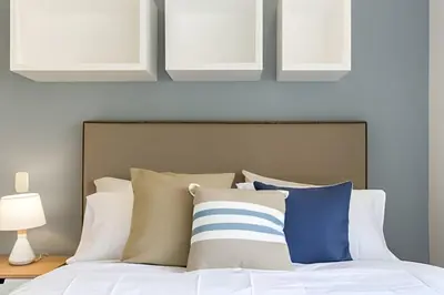 a bedroom with a bed with white and blue pillows at Provenza Life 603 - Chic Urban Retreat in El Poblado