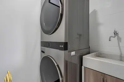 a bathroom with a washing machine and a sink at Clase 48 apt1002 - Loft with Panoramic Views and AC in Sabaneta