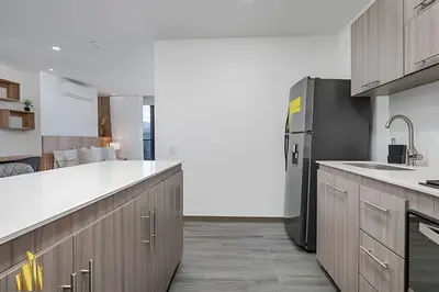 a kitchen with a refrigerator and a white counter top at Clase 48 apt1002 - Loft with Panoramic Views and AC in Sabaneta
