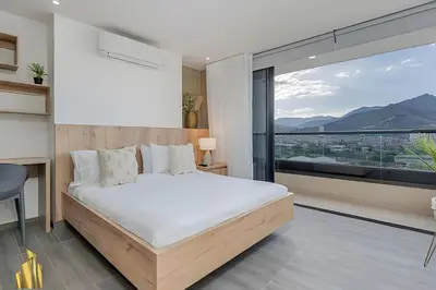 a bedroom with a bed and a large window at Clase 48 apt1002 - Loft with Panoramic Views and AC in Sabaneta