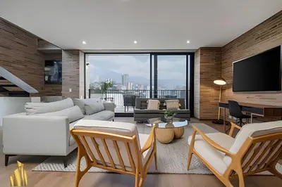 a living room with white furniture and a tv at C36 apto. 802 - Luminoso Dúplex con Vistas Panorámicas in Medellín