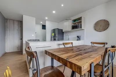 a kitchen with a wooden table and chairs at Class 48 apto. 1303 - Luminoso / Vistas / Balcón in Sabaneta