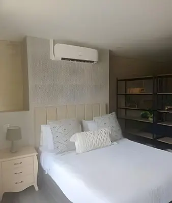 a bedroom with a white bed with a night stand at Class 48 apto. 1401 - Panorámico para nómadas digital/AC in Sabaneta