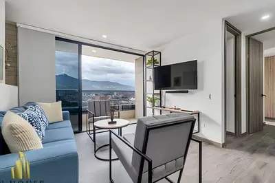 a living room with a blue couch and a tv at Class 48 apto. 1404 - Vistas modernas de la ciudad / AC in Sabaneta