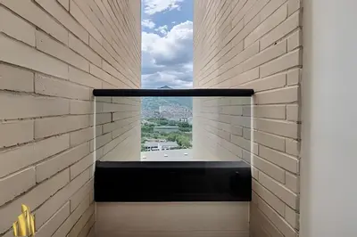 a room with a window in a brick wall at Class 48 apto. 1503 - Tranquilidad moderna/Balcón priv in Sabaneta
