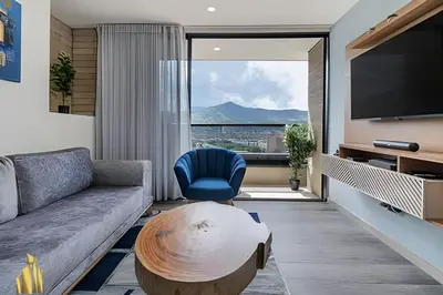 a living room with a couch and a table and a tv at Class 48 apto. 1503 - Tranquilidad moderna/Balcón priv in Sabaneta