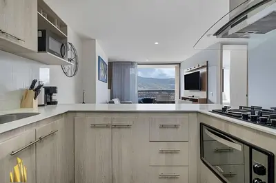 a kitchen with white counters and a large window at Class 48 apto. 1503 - Tranquilidad moderna/Balcón priv in Sabaneta