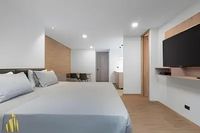 a bedroom with a large white bed and a flat screen tv at Class 48 Apt 2201 - Apt en Sabaneta con balcón privado in Sabaneta