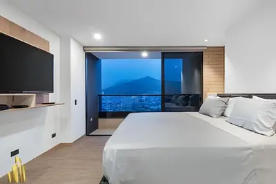 a bedroom with a large white bed and a large window at Class 48 Apt 2201 - Apt en Sabaneta con balcón privado in Sabaneta