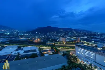 a city at night with a mountain in the background at Class 48 Apt. 2203 - Apt moderno y acogedor balcón priv in Sabaneta
