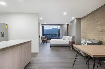a hotel room with a bed and a couch at Class 48 Apt. 2301 - Luces de ciudad/Loft/Balcón priv in Sabaneta