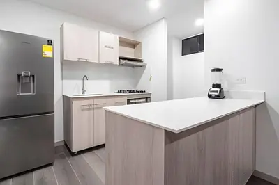 a kitchen with a refrigerator and a counter top at Class 48 Apt. 2302 - Íntimo loft con balcón privado in Sabaneta