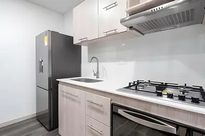 a kitchen with a stove and a refrigerator at Class 48 Apt. 2302 - Íntimo loft con balcón privado in Sabaneta