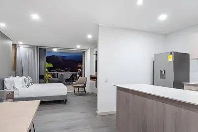 a hotel room with a bed and a kitchen at Class 48 Apt. 2302 - Íntimo loft con balcón privado in Sabaneta