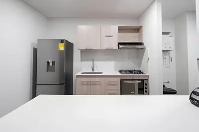 a white kitchen with a refrigerator and a sink at Class 48 Apt. 2302 - Íntimo loft con balcón privado in Sabaneta