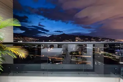 a view of a city from a balcony at night at Class 48 Apt. 2302 - Íntimo loft con balcón privado in Sabaneta