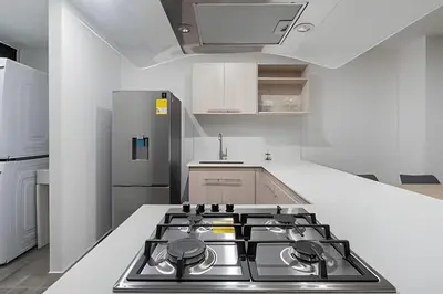 a kitchen with a stove top in a white kitchen at Class 48 Apt. 2303 - Loft de alta clase -balcón privado in Sabaneta