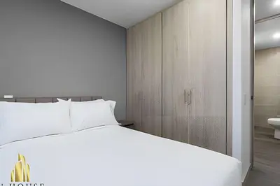a bedroom with a white bed and a bathroom at Class 48 Apt. 2304 - Apto con balcón privado/Sabaneta in Sabaneta