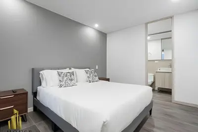 a white bedroom with a large bed and a bathroom at Class 48 Apt. 2304 - Apto con balcón privado/Sabaneta in Sabaneta
