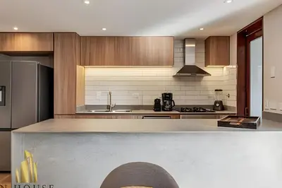 a kitchen with wooden cabinets and a counter top at La Mannuela 505 - Stylish Living in El Poblado in El Poblado