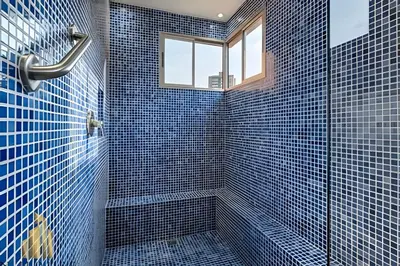 a blue tiled bathroom with a shower and a window at La Mannuela 505 - Stylish Living in El Poblado in El Poblado
