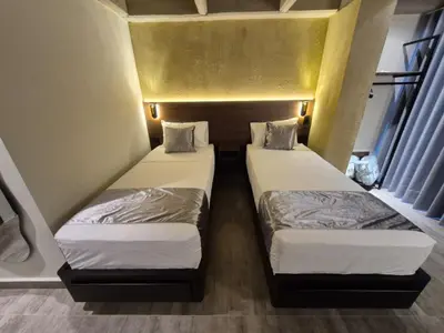 two beds in a small room with a yellow wall at Mali Experience in Rionegro