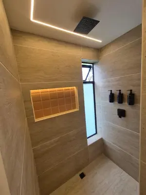a bathroom with a shower with wooden walls and a window at Mali Experience in Rionegro