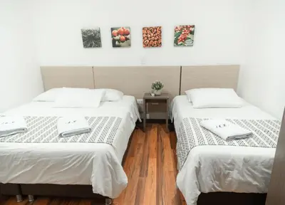a room with two beds and a table at Hotel Quinta del Café in Fredonia