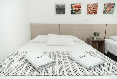 a white bed with two white pillows on it at Hotel Quinta del Café in Fredonia