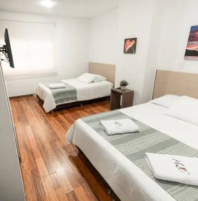 two beds in a room with wooden floors at Hotel Quinta del Café in Fredonia