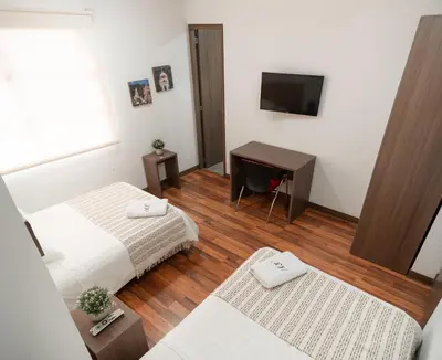 a hotel room with two beds and a television at Hotel Quinta del Café in Fredonia