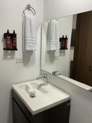 a bathroom with a sink and a mirror and towels at Hotel Quinta del Café in Fredonia