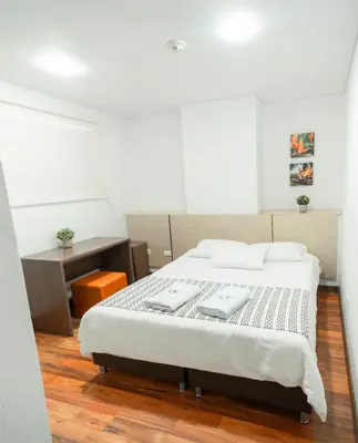 a bedroom with a large bed and a desk at Hotel Quinta del Café in Fredonia