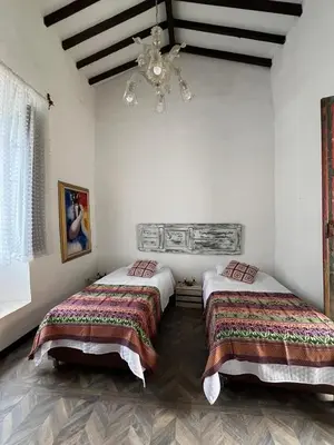 a bedroom with two beds and a chandelier at Hotel Art Boutique Las Cardenas in Carolina del Principe