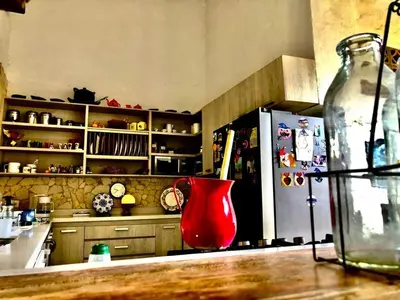 a kitchen with a red vase and a refrigerator at Hotel Art Boutique Las Cardenas in Carolina del Principe