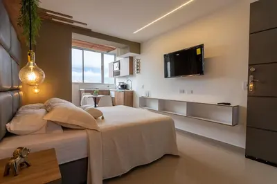 a bedroom with a bed and a tv on the wall at ApartaSuite Central Luxe in Itagüí